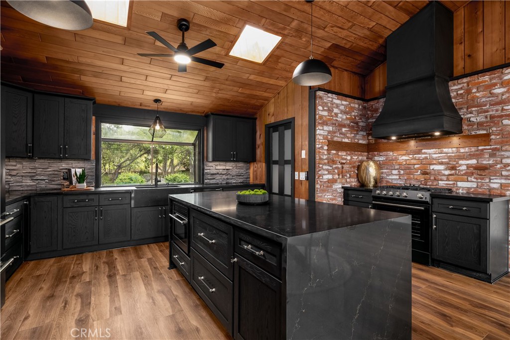 7744 West Lilac Road Bonsall, CA 92003 - Photo 4 of 60 a kitchen with stainless steel appliances granite countertop a sink a stove and a wooden cabinets