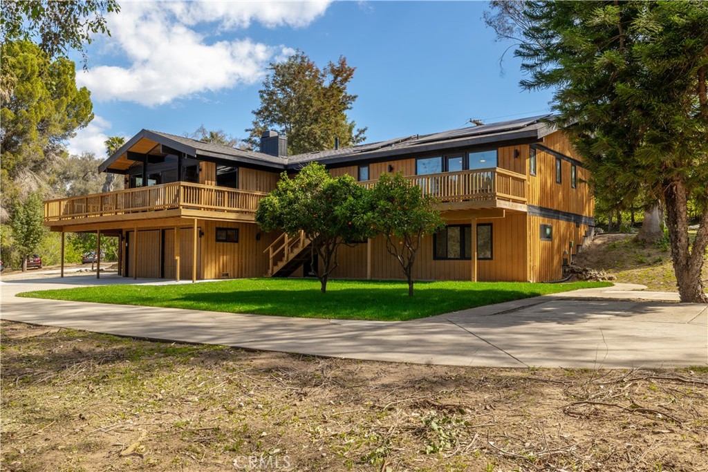 7744 West Lilac Road Bonsall, CA 92003 - Photo 46 of 60 a front view of a house with a yard and trees