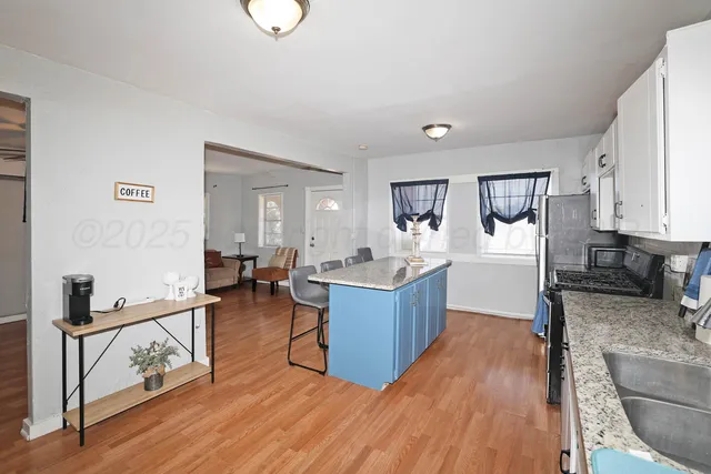 a large kitchen with cabinets wooden floor and stainless steel appliances