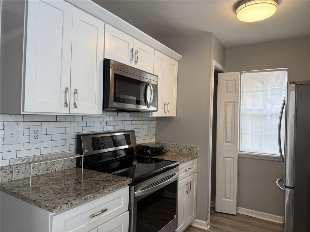 105 Hawkstone Way Alpharetta, GA 30022 - Photo 11 of 23 a kitchen with stainless steel appliances granite countertop a sink stove and microwave