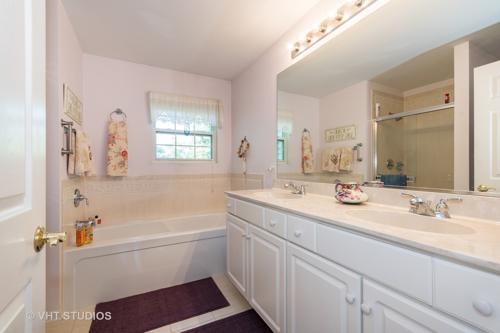 3132 Raphael Court St. Charles, IL 60175 - Photo 8 of 14 a bathroom with a sink a bathtub a mirror a vanity and a shower