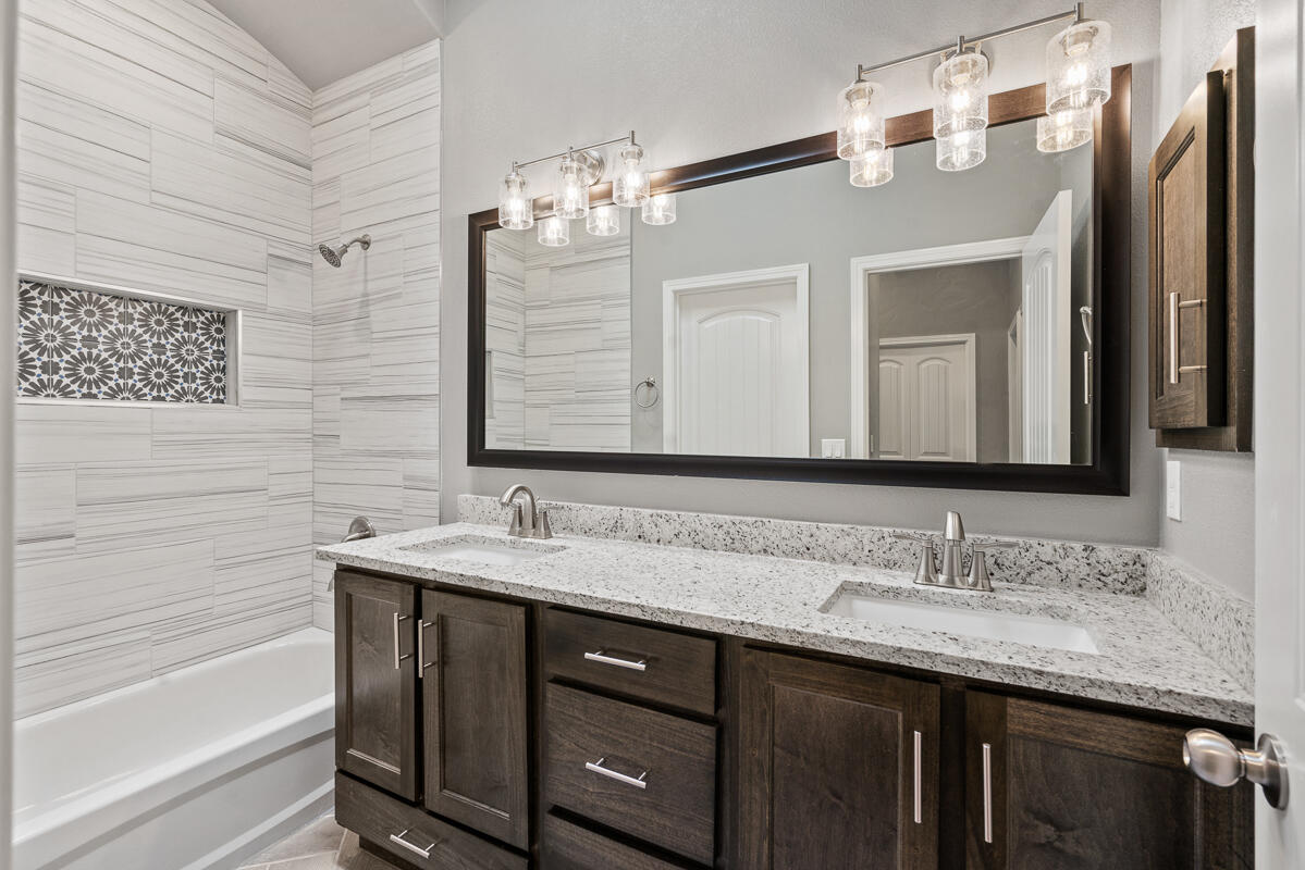 6026 Spring Ridge Sunland Park, NM 88008 - Photo 16 of 17 a bathroom with a granite countertop sink a large mirror and a bathtub