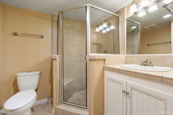 a bathroom with a toilet a sink and glass door