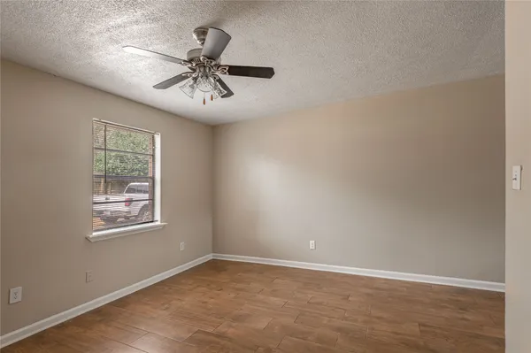 an empty room with a window and a ceiling fan