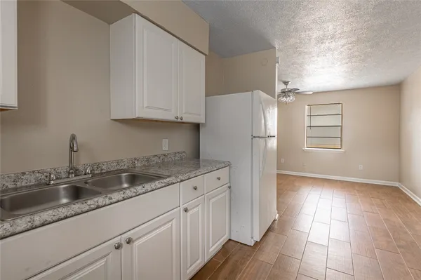 a kitchen with a sink a refrigerator and cabinets