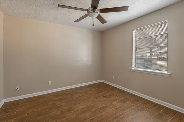 an empty room with a window and ceiling fan
