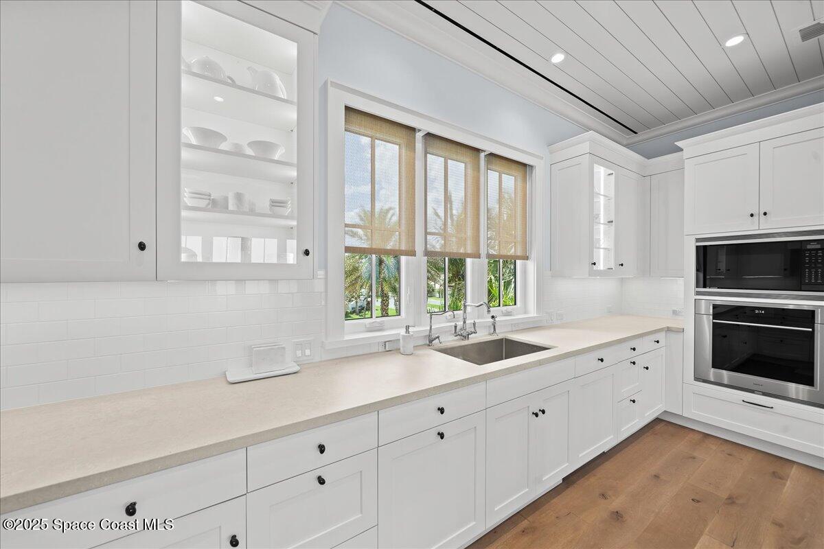 5525 Jimmy Buffett Mem Highway Melbourne Beach, FL 32951 - Photo 19 of 56 a kitchen with granite countertop white cabinets and a window