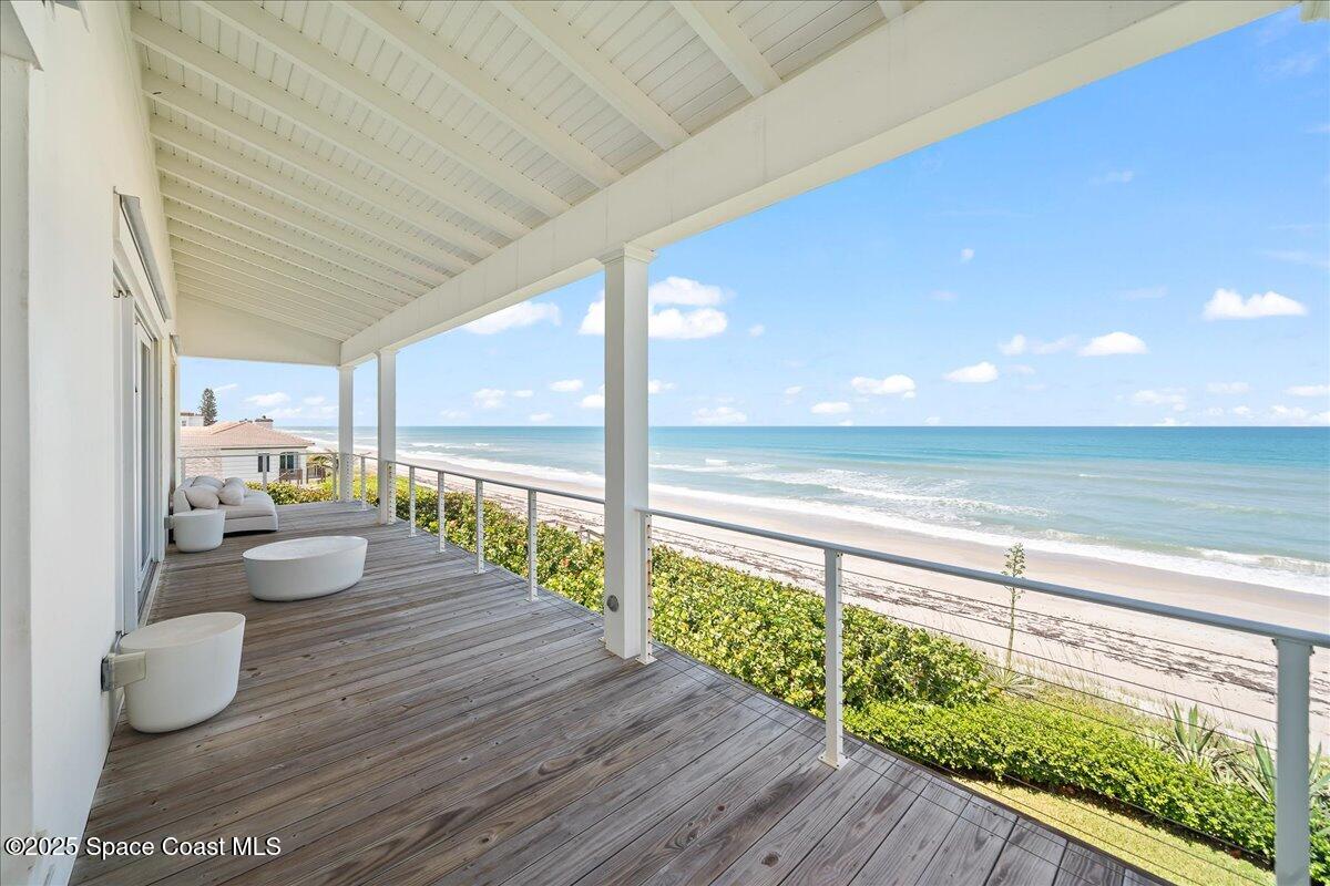 5525 Jimmy Buffett Mem Highway Melbourne Beach, FL 32951 - Photo 36 of 56 a view of a balcony with chair and wooden floor