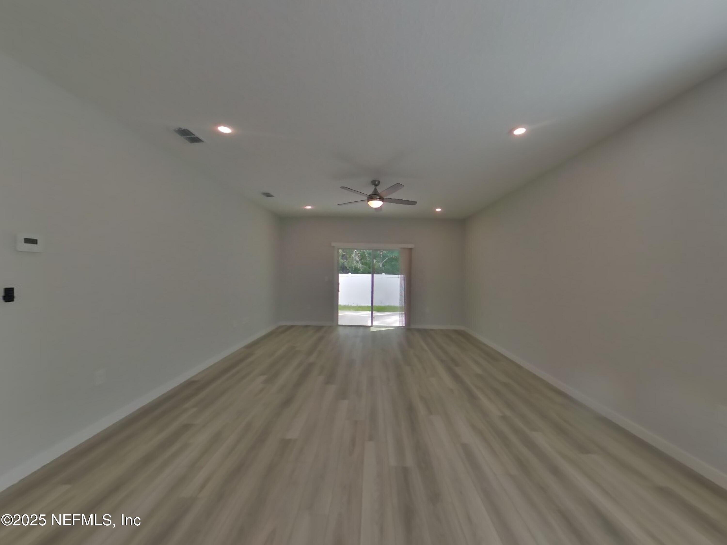 14897 Praline Court Jacksonville, FL 32218 - Photo 3 of 17 an empty room with wooden floor and windows