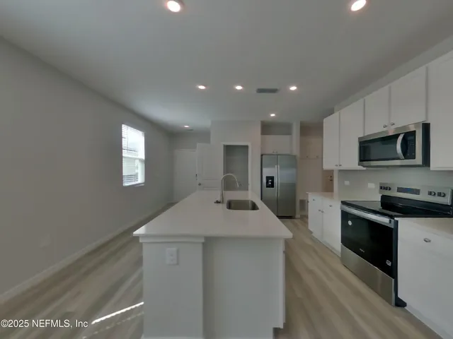 a kitchen with granite countertop a sink a stove and microwave