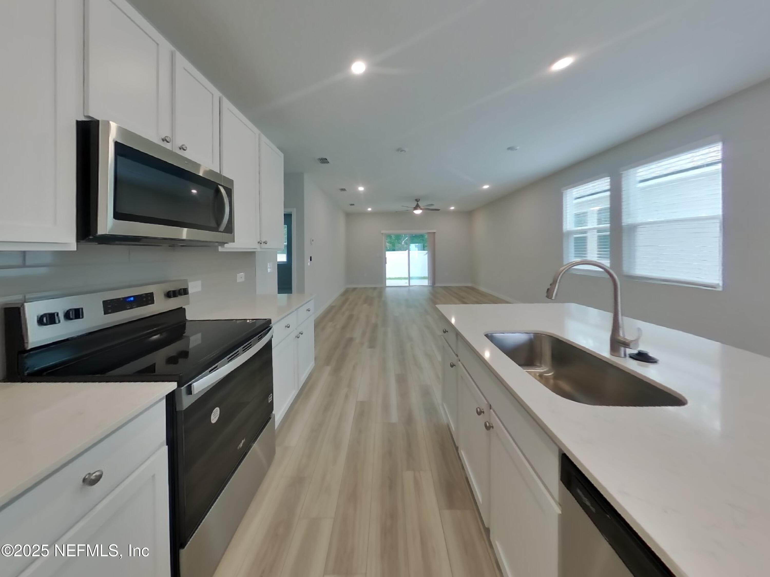 14897 Praline Court Jacksonville, FL 32218 - Photo 5 of 17 a kitchen with granite countertop a sink a stove and microwave