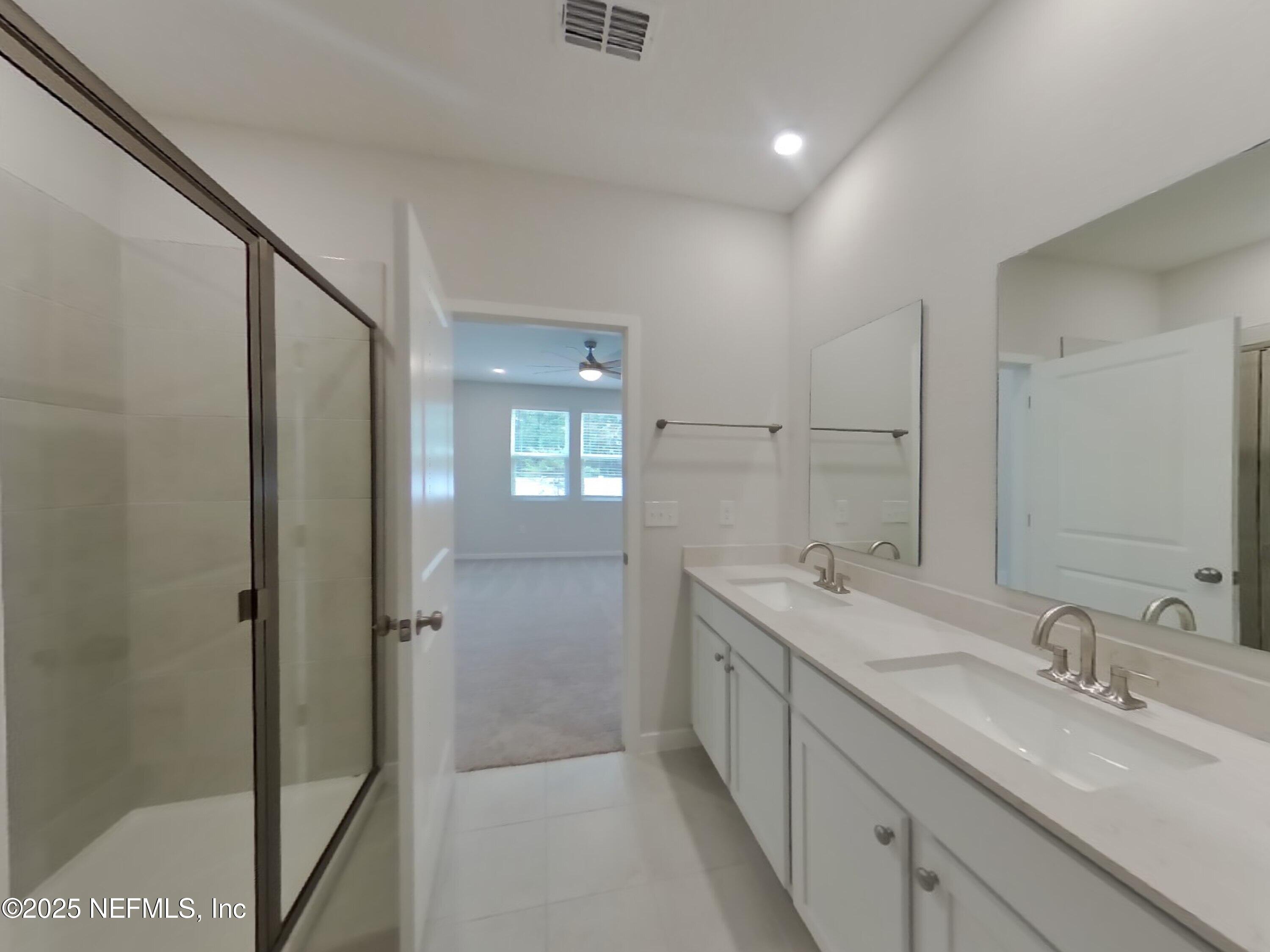 14897 Praline Court Jacksonville, FL 32218 - Photo 8 of 17 a spacious bathroom with a double vanity sink a mirror and a shower