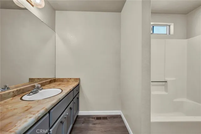 a bathroom with a granite countertop sink and a mirror