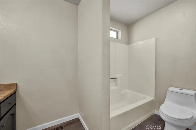 a white toilet sitting next to a bath tub