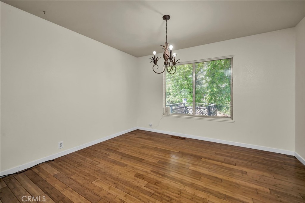 16927 Greenridge Road Hidden Valley Lake, CA 95467 - Photo 9 of 25 a view of an empty room with wooden floor fridge and a window