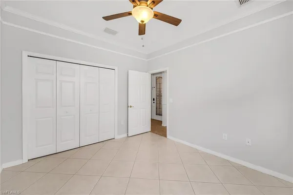 an empty room with closet and a chandelier fan