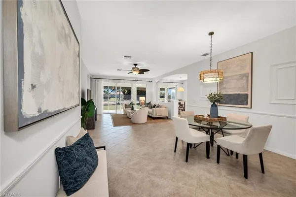 a living room with furniture a chandelier and a window