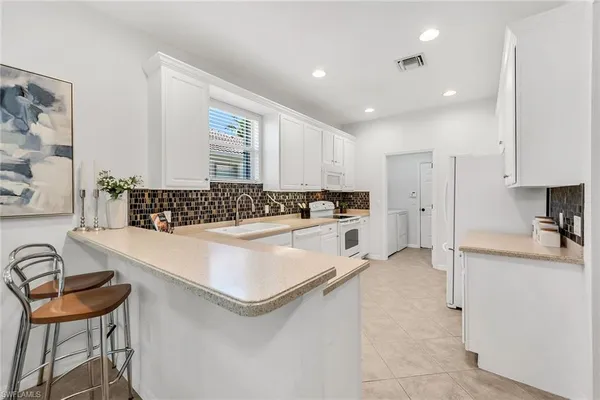 a kitchen with granite countertop a stove a sink and a refrigerator