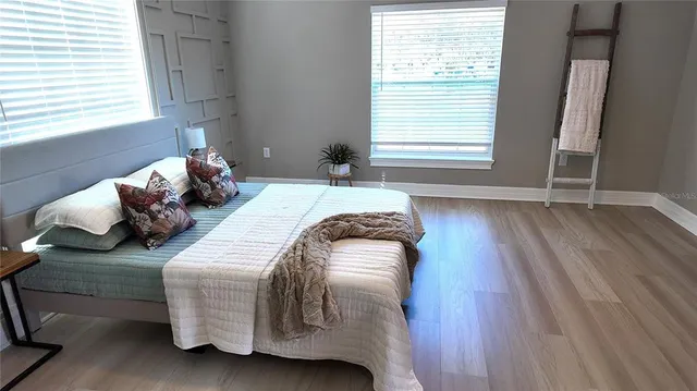 a bedroom with a bed and wooden floor