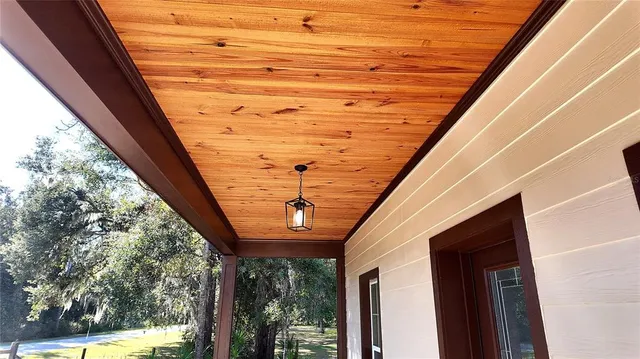 a view of a hallway with wooden floor and a livingroom