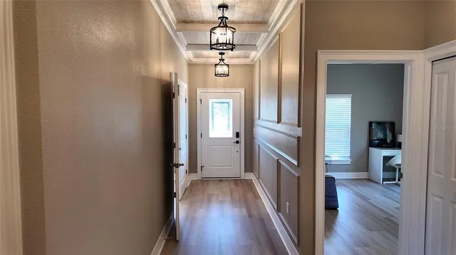 a view of a hallway with wooden floor and staircase