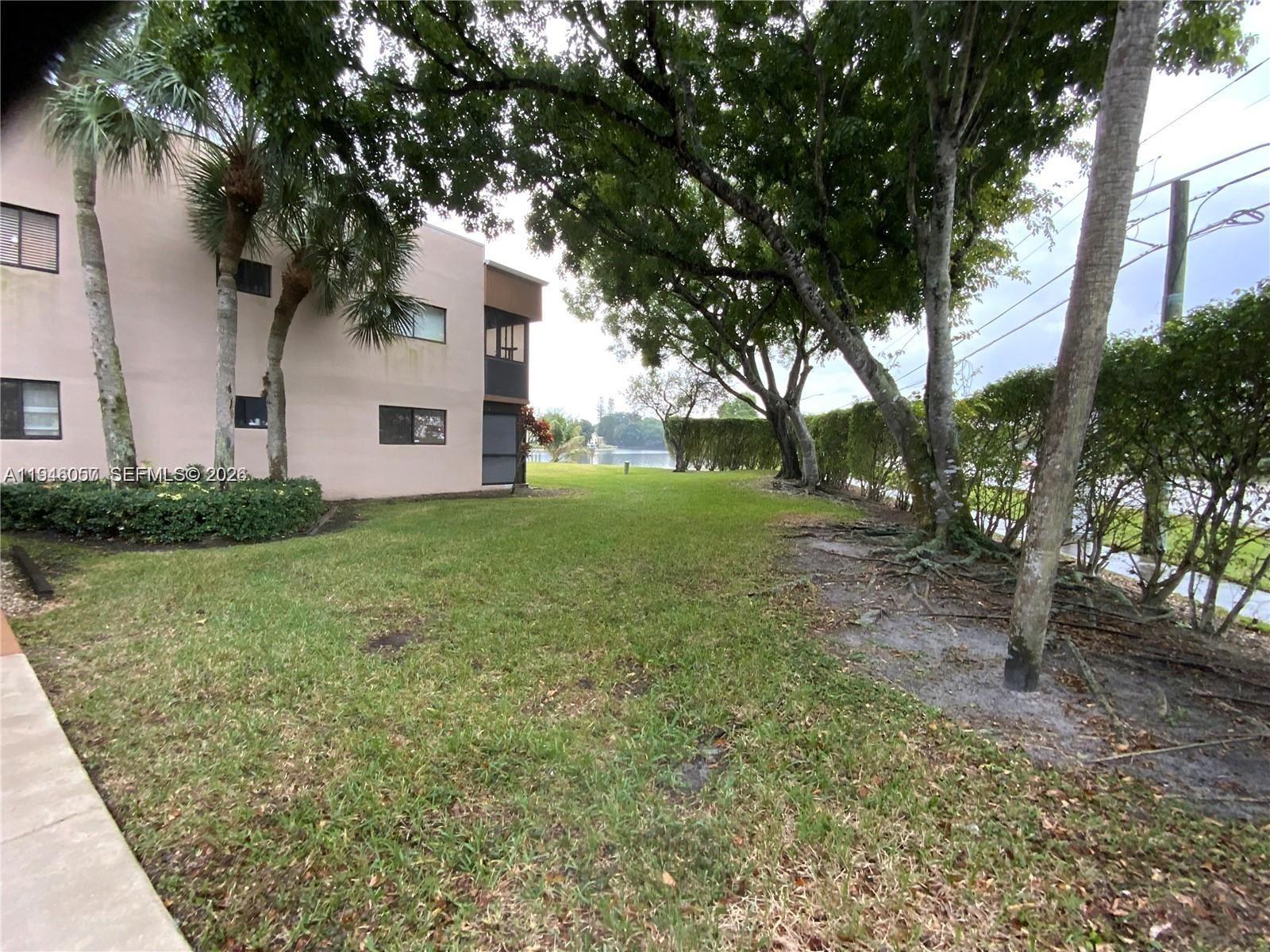 9920 Northwest 68th Place, Unit 110 Tamarac, FL 33321 - Photo 19 of 22 a front view of a house with garden
