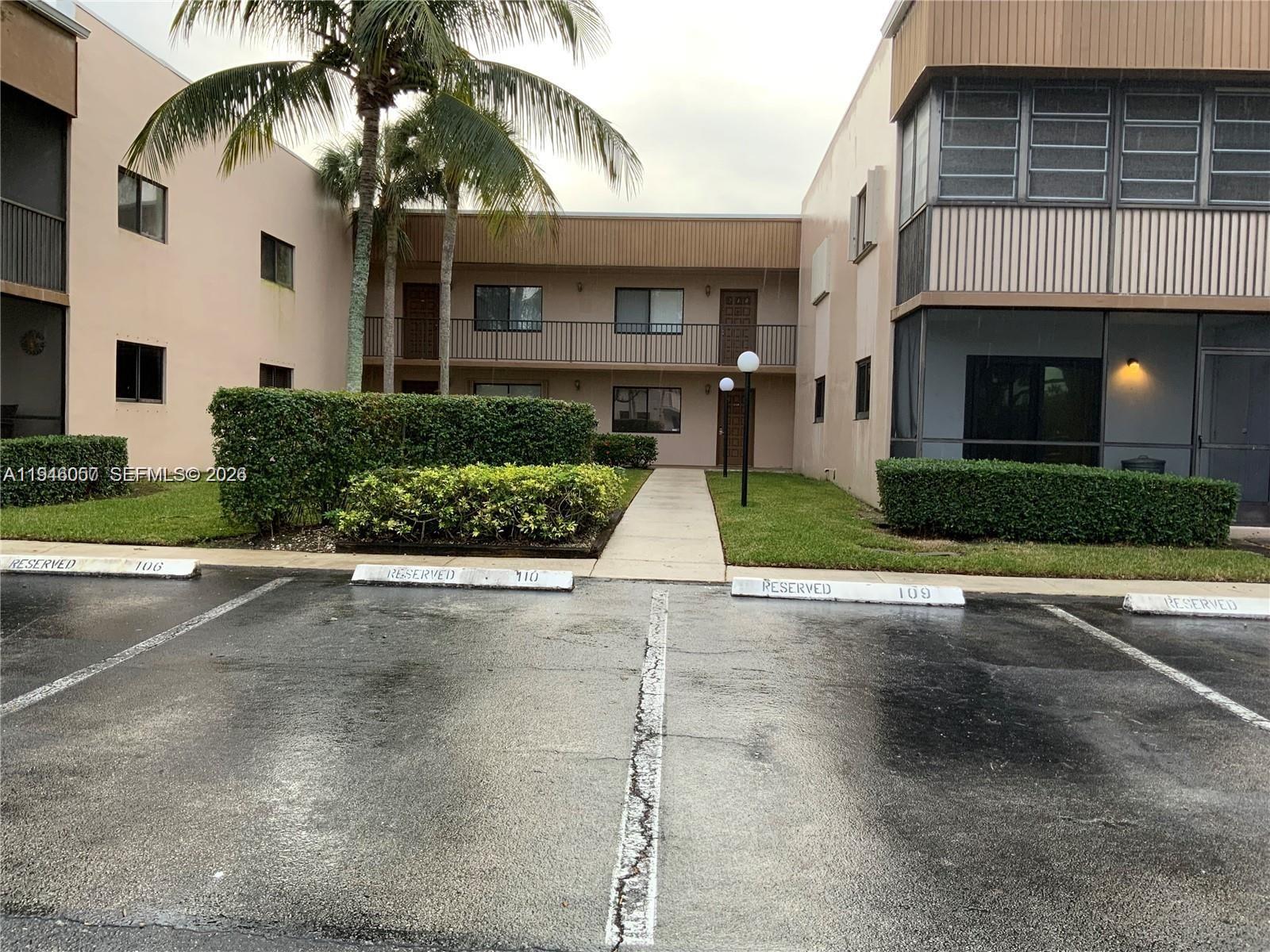 9920 Northwest 68th Place, Unit 110 Tamarac, FL 33321 - Photo 2 of 22 a front view of a house with a yard and garage