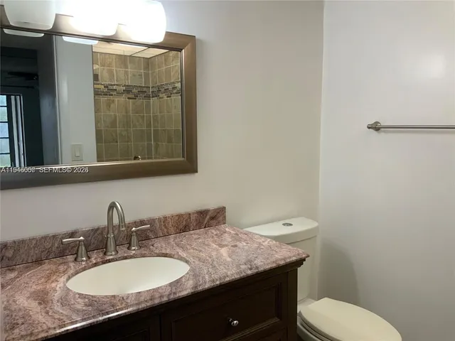 an empty room with wooden floor closet and windows
