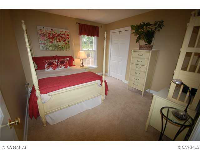 14331 Crossings Ridge Drive Midlothian, VA 23113 - Photo 11 of 12 a bedroom with a bed with a white comforter and pillows