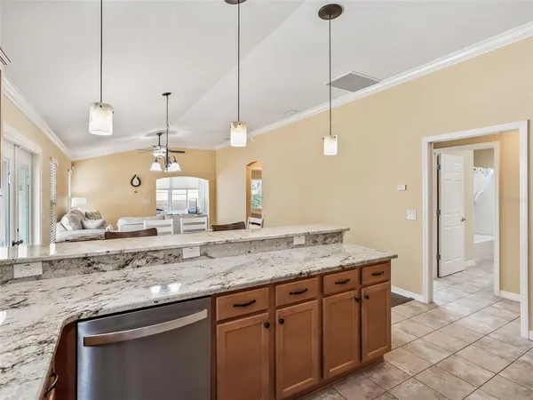 a kitchen with stainless steel appliances granite countertop a sink a stove a refrigerator a center island with wooden floor and cabinets