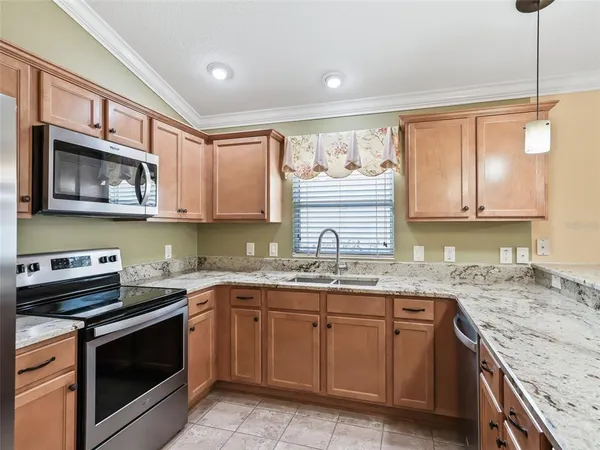 a kitchen with granite countertop a stove microwave and refrigerator