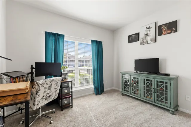 a livingroom with lounge chair and a flat screen tv