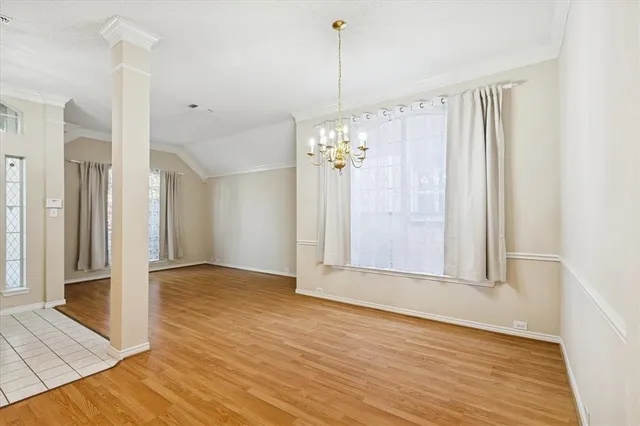 a view of a hallway with wooden floor and a chandelier