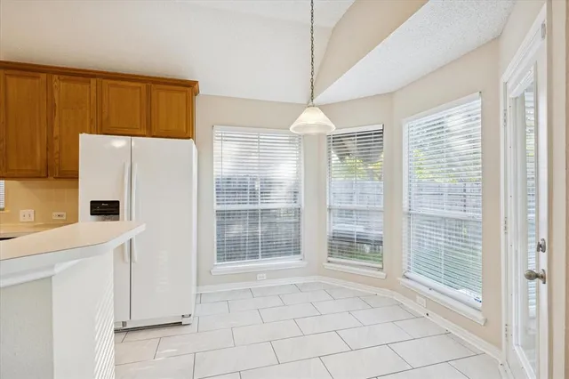 a view of empty room with window and refrigerator