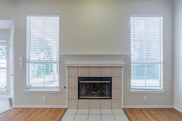 an empty room with a fireplace and windows