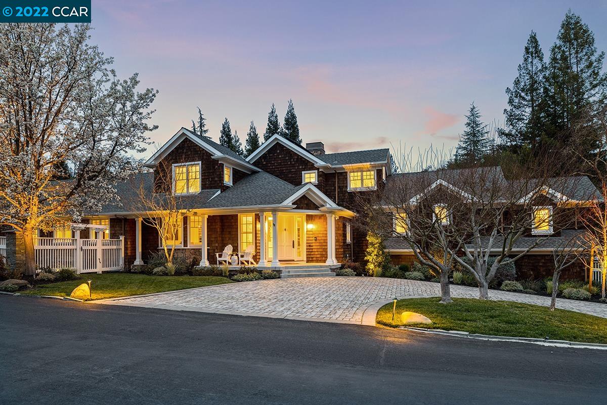 a view of a white house with a big yard and large trees