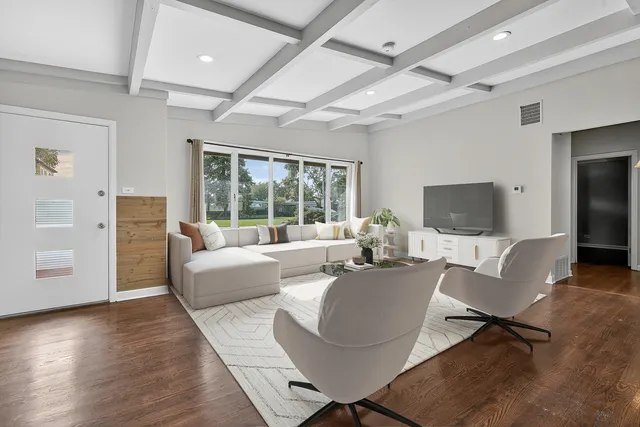 a living room with couches a coffee table and a flat screen tv with wooden floor