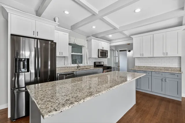 a kitchen with stainless steel appliances granite countertop a refrigerator sink and stove