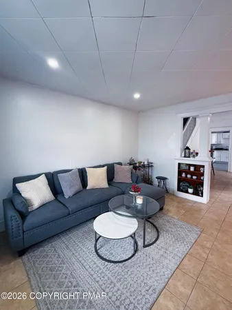 a living room with furniture a rug and a wall painting