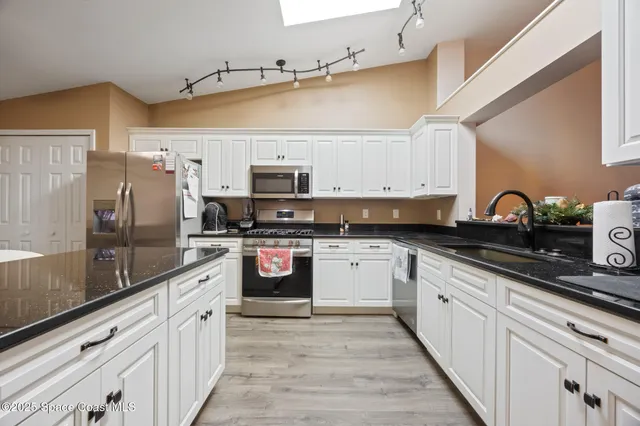 a kitchen with stainless steel appliances a stove a sink and a refrigerator