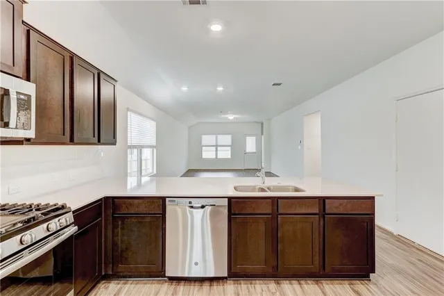 a kitchen with granite countertop a sink cabinets and wooden floor