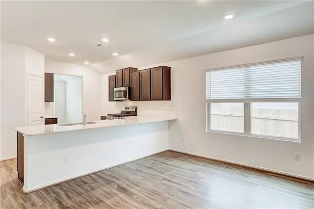 a view of a kitchen with center island and wooden floor