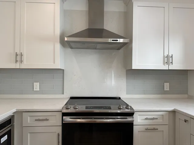 a stove top oven sitting inside of a kitchen