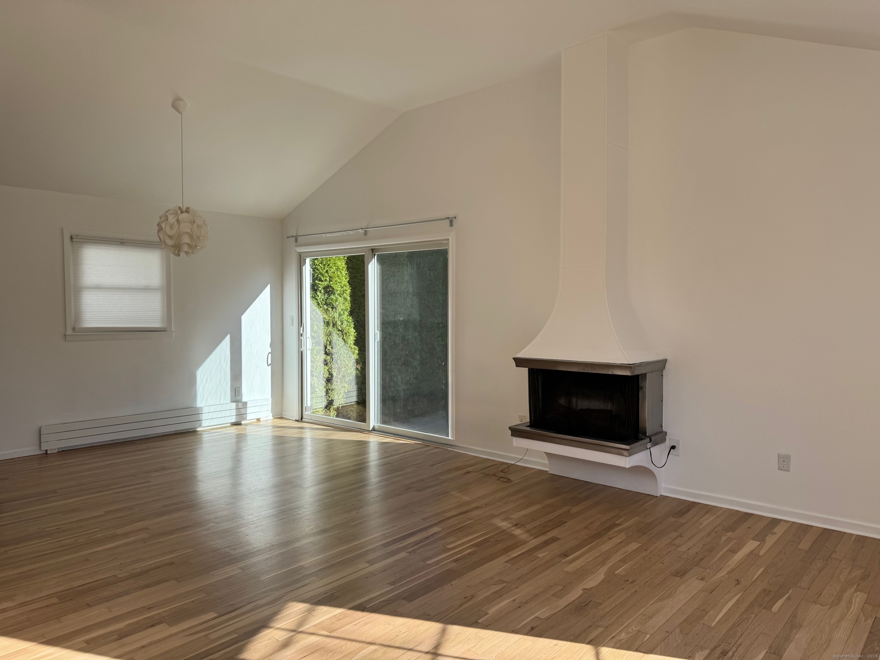 15 Sunwich Road Norwalk, CT 06853 - Photo 7 of 33 a view of an empty room with wooden floor fireplace and a window