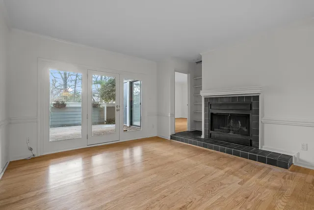 wooden floor fireplace and windows in an empty room