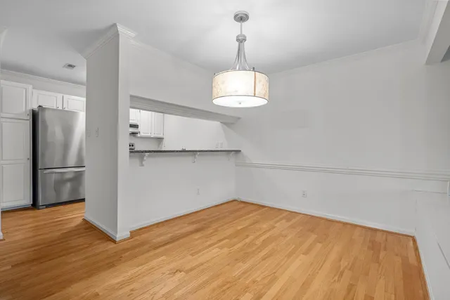 a view of a room with a chandelier and wooden floor