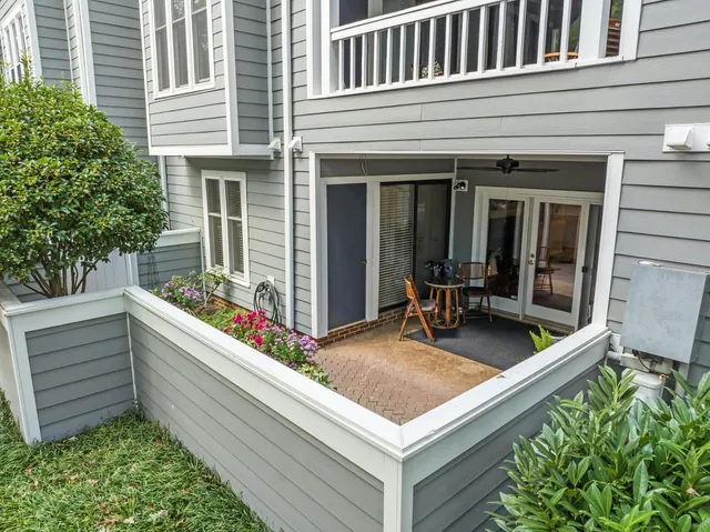 a view of a patio with chairs and potted plants