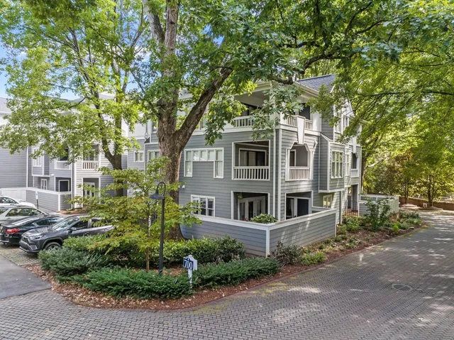 a front view of a house with yard and parking