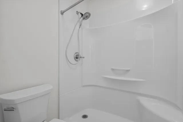 a view of a white house with large windows and a small yard