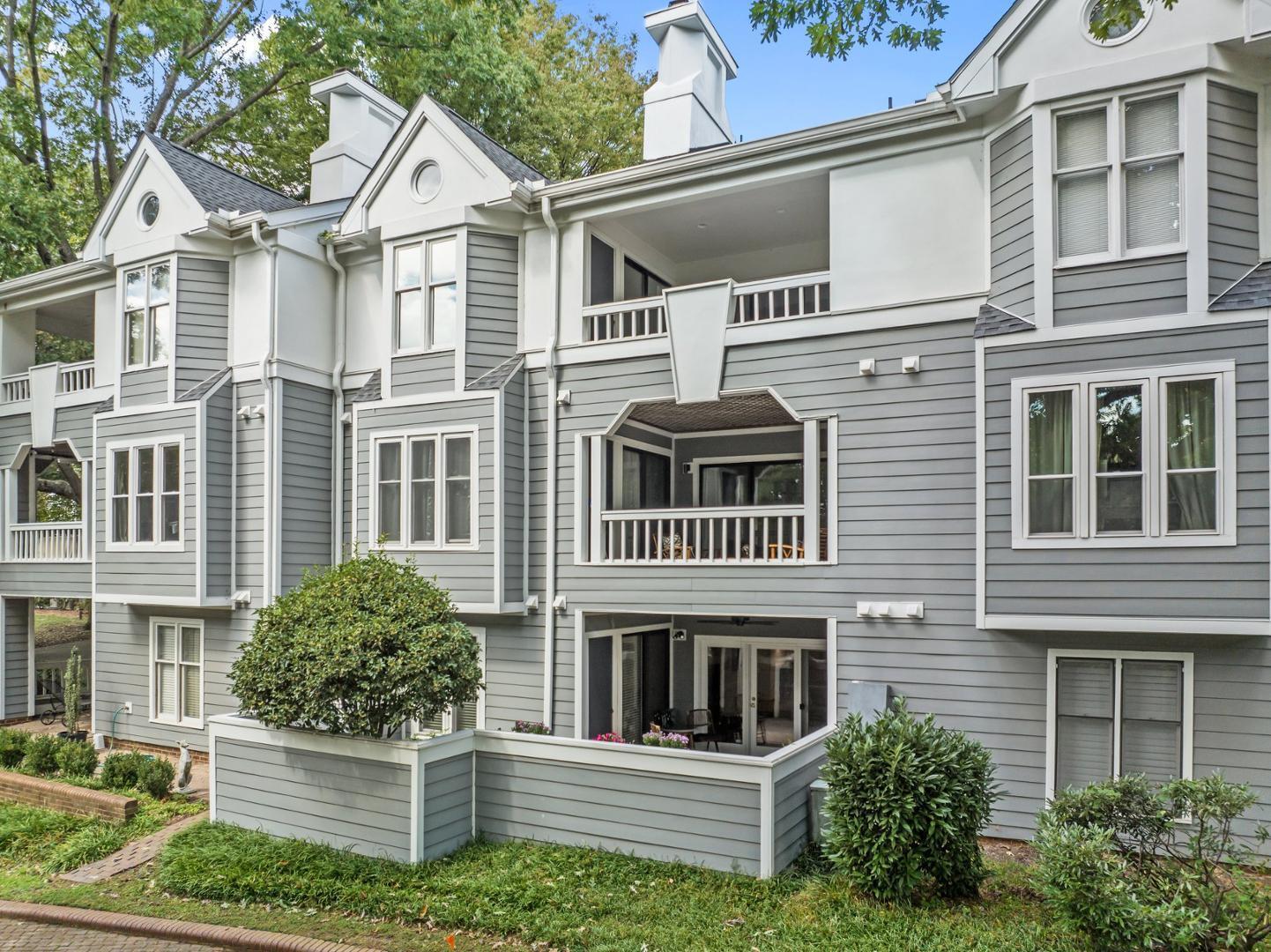 700 Bishops Park Drive, Unit 102 Raleigh, NC 27605 - Photo 40 of 56 a view of a white house with large windows and a small yard